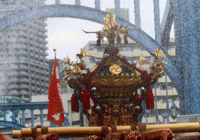水掛け祭りのお神輿と隅田川に架かる橋の風景