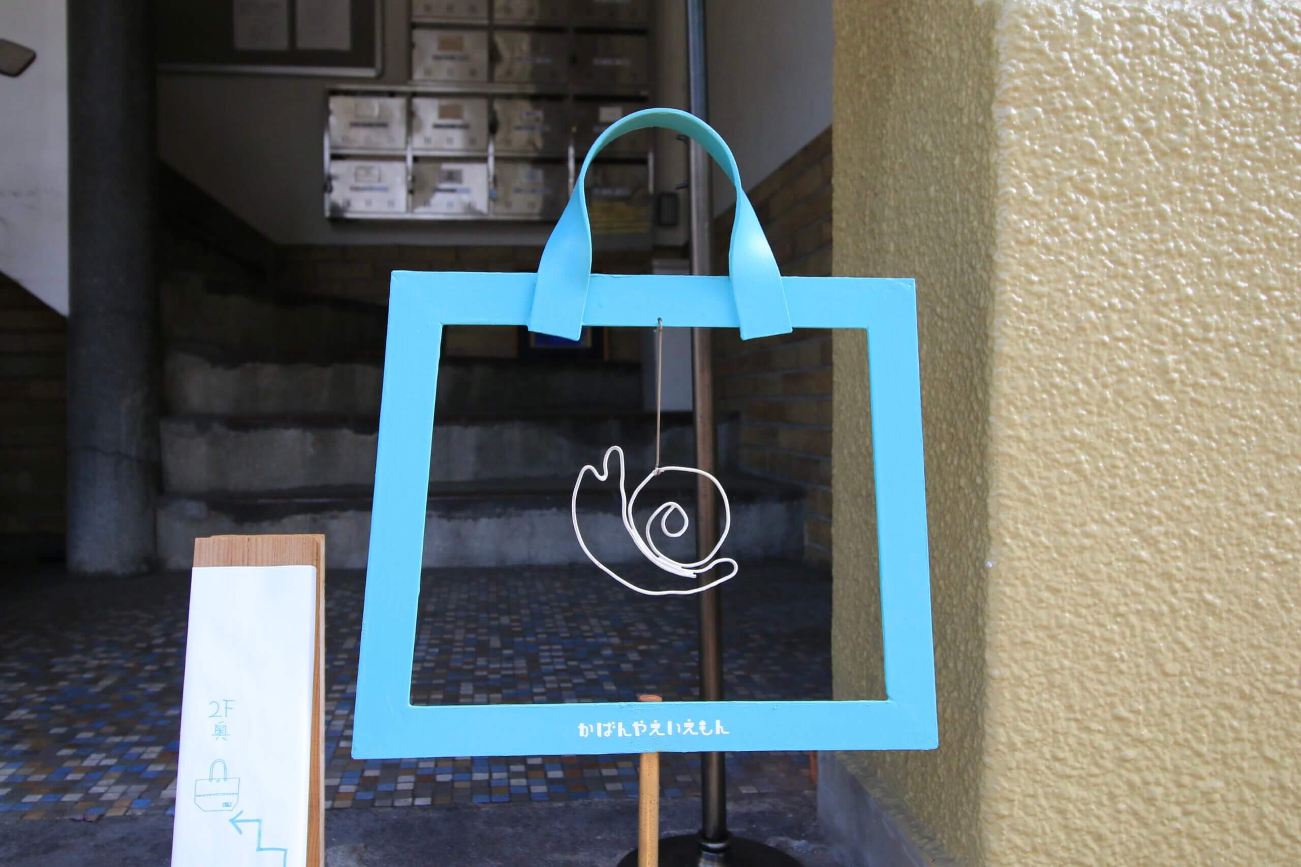 かばんやえいもんのカタツムリのマークのある看板