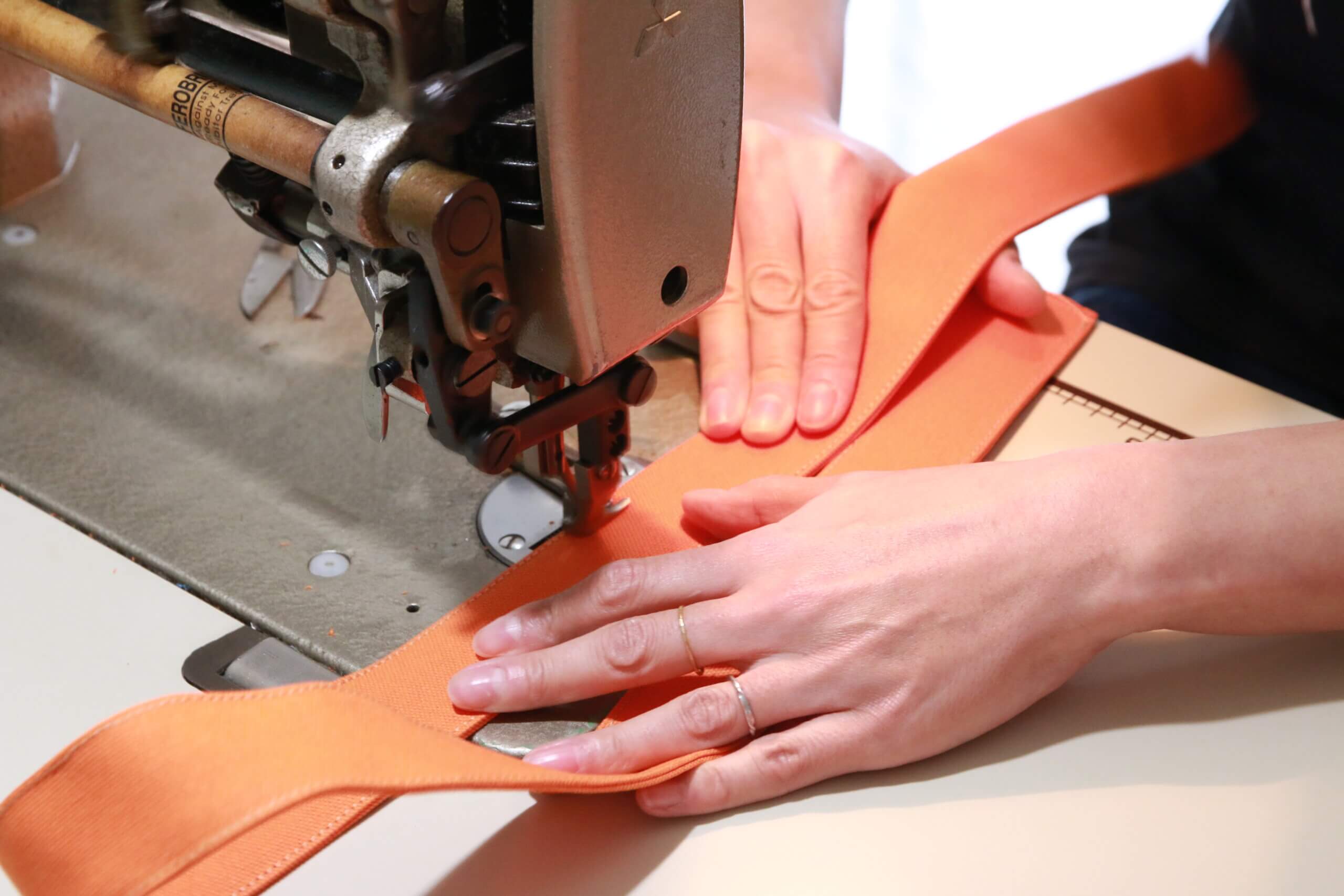 清洲寮の事務所にあるミシンでかばんを制作する女性オーナー