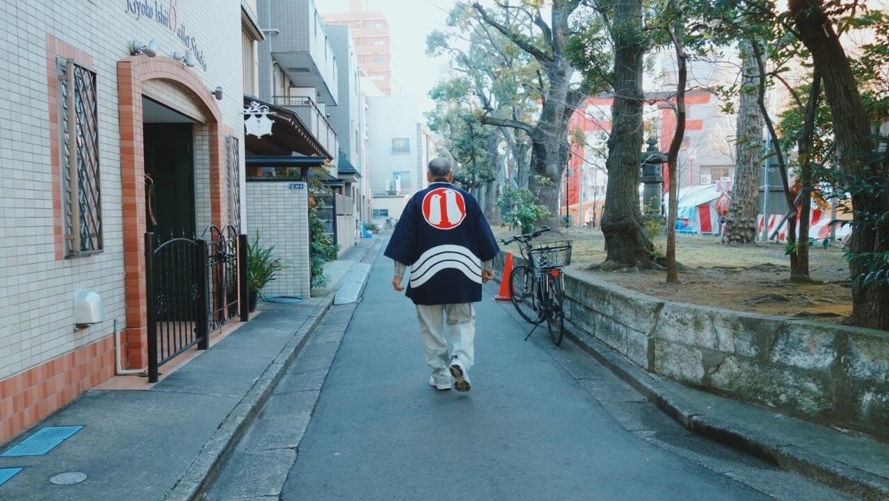 富岡八幡宮の法被を着て歩いてる人、日常の深川の風景