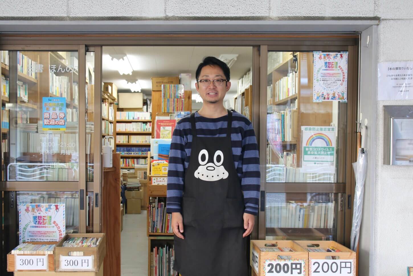 清澄白河の古本屋:のらくろのエプロンを着用し店頭に立つオーナー