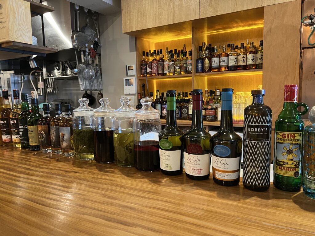 オープンキッチンのカウンターに並べられた洋酒の瓶