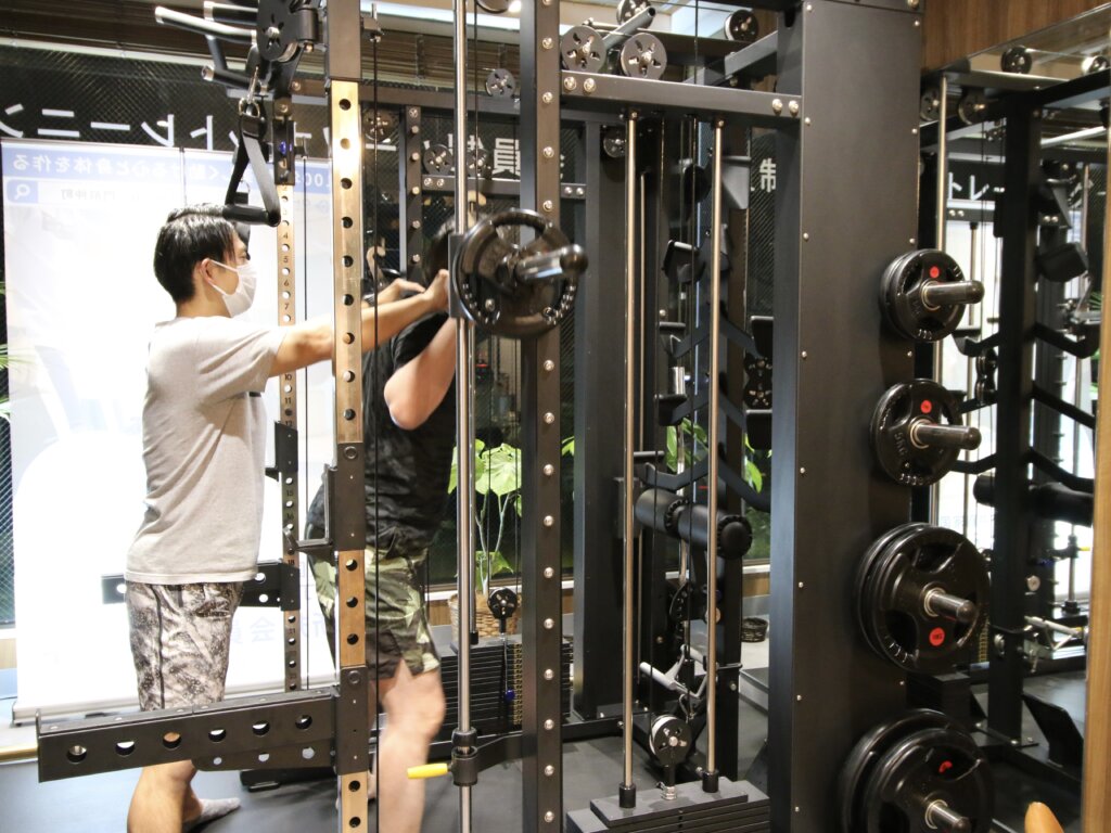マシンでトレーニングする生徒とトレーナー